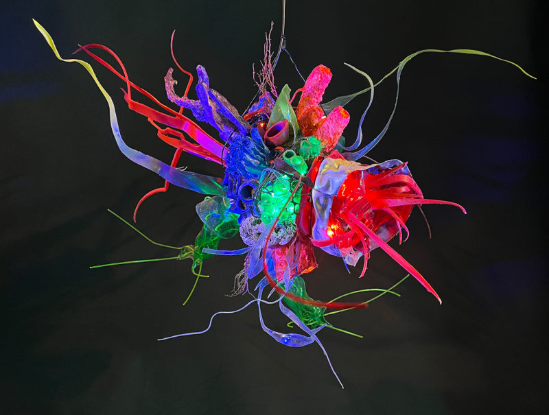 "Faux Ecologies / the Anthropocene Gardens + Artificial Reefs of the Nature-verse #4" 2023 /free-hanging sculptures/ reclaimed Ocean debris [sponges,seafans, and dead corals], up-cycled plastics from beach clean-ups and the artist's personal waste stream, LED's, fiber optics, acrylic paint, epoxy by [dNASAb]