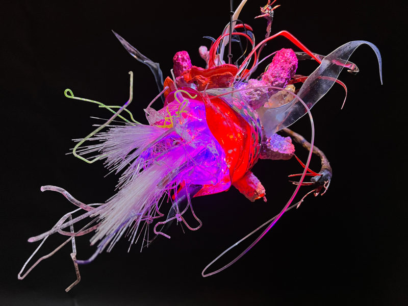 "Faux Ecologies / the Anthropocene Gardens + Artificial Reefs of the Nature-verse #7" 2014-2023 /free-hanging sculptures/ reclaimed Ocean debris [sponges,seafans, and dead corals], up-cycled plastics from beach clean-ups and the artist's personal waste stream, LED's, fiber optics, acrylic paint, epoxy by [dNASAb]